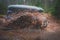 Suv offroad 4wd car rides through muddy puddle, off-road track road, with a big splash, during a jeeping competition