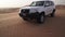 SUV at the top of the dune in the Rub al Khali desert, the wind chases the sand stock footage video