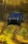 SUV or two black offroad cars on fall nature background. Offroad race in autumn forest. Car racing, extreme and four