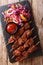 Suya- Roast African spicy skewered beef kebab is served with fresh vegetable salad and ketchup close-up. vertical top view
