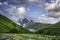 Svaneti mountain landscape, Georgia. Caucasus wild nature with snowy rocky mountains and grassy hills