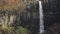 Svartifoss waterfall and unrecognizable tourists, long shot