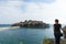 Sveti Stefan in Budva Montenegro Young girl traveler. Adriatic sea with boats and an old small town in a island. Stone luxury