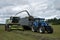 Svitavy, Czech Republic - 20.4.2019: Forage harvest. The New Holland tractor and Claas are harvested with clover for silage.