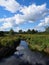 Swamp marsh water canal under summer sky