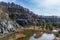 Swamped quarry with high dry grass, small pond, rock, Czech republic