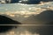 A swan crossing the Millstaetter lake in Austria during the sunset. The lake is surrounded by high Alps. Calm surface