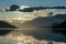 A swan crossing the Millstaetter lake in Austria during the sunset. The lake is surrounded by high Alps. Calm surface