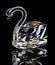 Swan figurine made of glass glitters on a black background