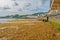 Swanage beach covered in brown seaweed at the outgoing tide on a summer morning