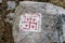 Swastika sign on grey stone at Thangu and Chopta valley in winter in Lachen. North Sikkim, India