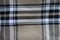 Swatch of beige, black and white flannel tartan fabric