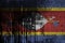 Swaziland flag depicted in paint colors on old and dirty oil barrel wall closeup. Textured banner on rough background