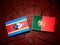 Swaziland flag with Portuguese flag on a tree stump isolated