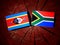 Swaziland flag with South African flag on a tree stump isolated