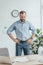 sweaty businessman in wet shirt standing in office with laptop documents