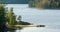 Sweden. Beautiful Small Swedish Wooden Log Cabin House On Rocky Island Coast In Summer Sunny Evening. Lake Or River