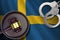 Sweden flag with judge mallet and handcuffs in dark room. Concept of criminal and punishment, background for judgement