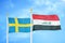 Sweden and Iraq two flags on flagpoles and blue sky