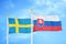 Sweden and Slovakia two flags on flagpoles and blue sky