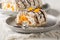 Swedish Budapest roll with hazelnut meringue and mandarins closeup on the plate. Horizontal