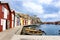 Swedish colorful fishing cottages in front of the bay with moored fishing and motor boats