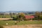 The Swedish flat farmlands with horses and farms during late summer in the landscape of SkÃ¥ne Scania