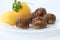 Swedish Kottbullar meatball with boiled potatoes and parsley on white plate on white background