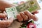 A Swedish pensioner holds a bunch of low denomination banknotes in her hands, Cost of living for a senior in Sweden, Pensions and