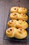 Swedish and scandinavian Christmas saffron buns Lussekatter on cooling tray, brown wooden background, vertical, copy space