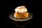 Swedish Semla in traditional glass plate isolated on black background with reflections, centered