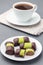 Swedish sweets punsch rolls or punschrullar, covered with green marzipan, on  white plate, served with coffee,  vertical