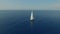 Sweeping aerial shot of large sailboat off beautiful coastline