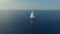 Sweeping aerial shot of large sailboat off beautiful coastline