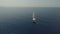 Sweeping aerial shot of large sailboat off beautiful coastline