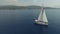 Sweeping aerial shot of large sailboat off beautiful coastline