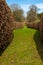 A sweeping brown hedge cuts through the green garden in Derbyshire, England