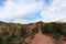 Sweeping landscape of evergreens and red rock and dirt at the Garden of the Gods in Colorado