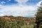 Sweeping landscape of Red Rock mountains and rock formations dotted with evergreen trees at Garden of the Gods in Colorado