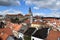 Sweeping view of ÄŒeskÃ½ Krumlov with its State Castle, former church of St. JoÅ¡t, historical buildings and houses.