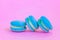 Sweet almond colorful unicorn blue macaron or macaroon dessert cake isolated on trendy pink pastel background. French