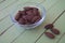 Sweet almonds in a transparent bowl on green wood