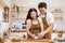 Sweet Asian new marriage couple stay home, spend time together in kitchen. Young attractive man and woman looking to ingredients o