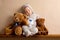 Sweet baby boy in bear overall, sleeping on a shelf with teddy b