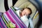 Sweet baby boy sleeping peacefully in a car seat. Newborn being carried in a car seat