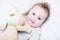 Sweet baby girl in a white round crib with pink bunny toy