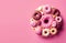 Sweet baked donuts with decoration on a pink background. Generative AI, generative artificial intelligence