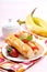 Sweet banana hotdog with strawberry sauce on white plate