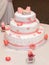 Sweet baptize cake with pink sugar shoes and burning candles