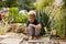 Sweet barefoot toddler child, playing with little snail after rain in garden